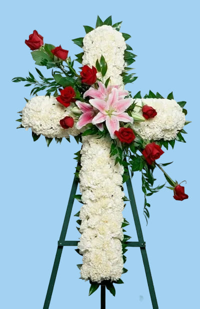 Floral arrangement in the shape of a cross with white, red, and pink flowers on a white background.