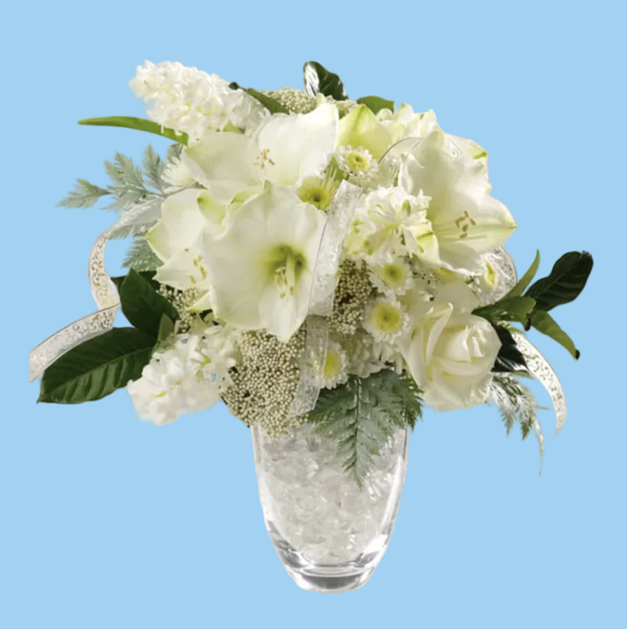 Bouquet of white flowers in a clear glass vase on a white surface.