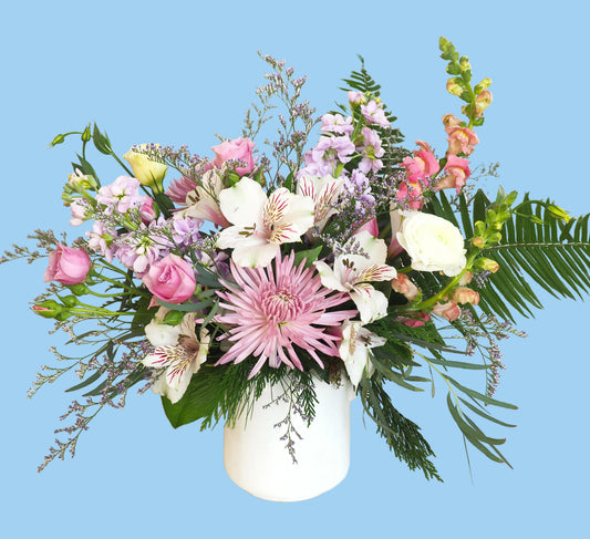 Bouquet of flowers with pink and white flowers in a white vase on a white background