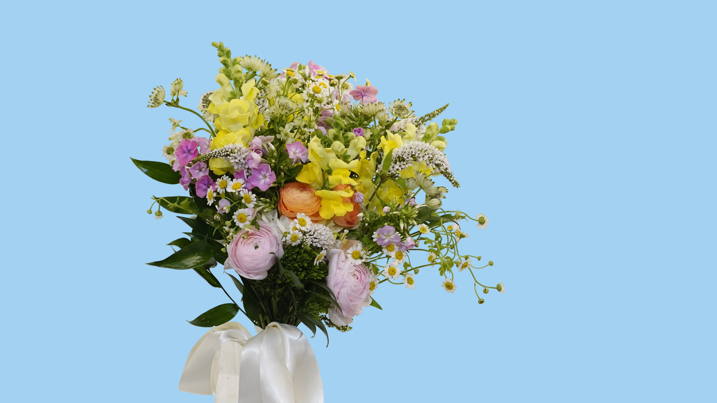 Bouquet of flowers with a white ribbon on a light background