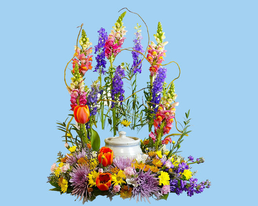 Colorful floral arrangement with a teapot on a white background