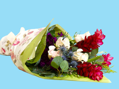 Bouquet of flowers wrapped in green paper with a white background